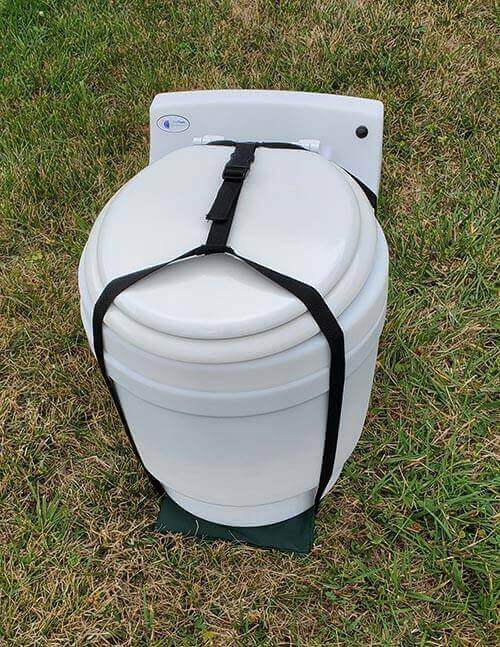 Laveo Dry Flush Toilet with Carrying Harness by Cabin Depot for easy transport on grass.