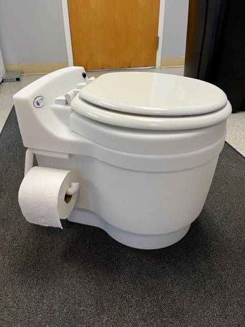 Laveo Dry Flush Mounted Toilet Paper Holder by Cabin Depot, attached to a portable toilet for convenient use.